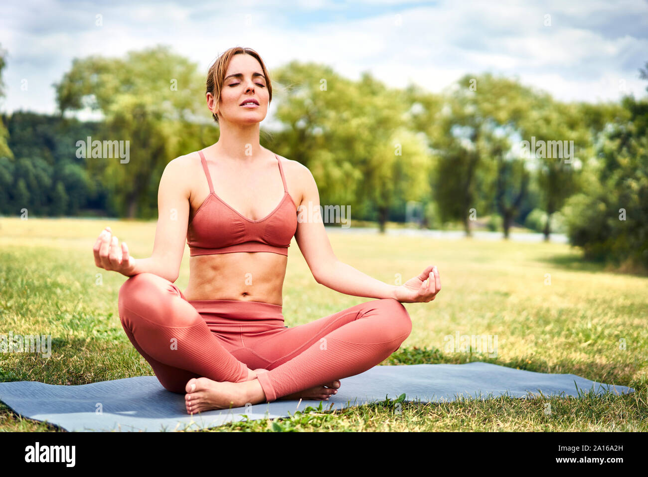 Frau Yoga im Park meditieren Stockfoto