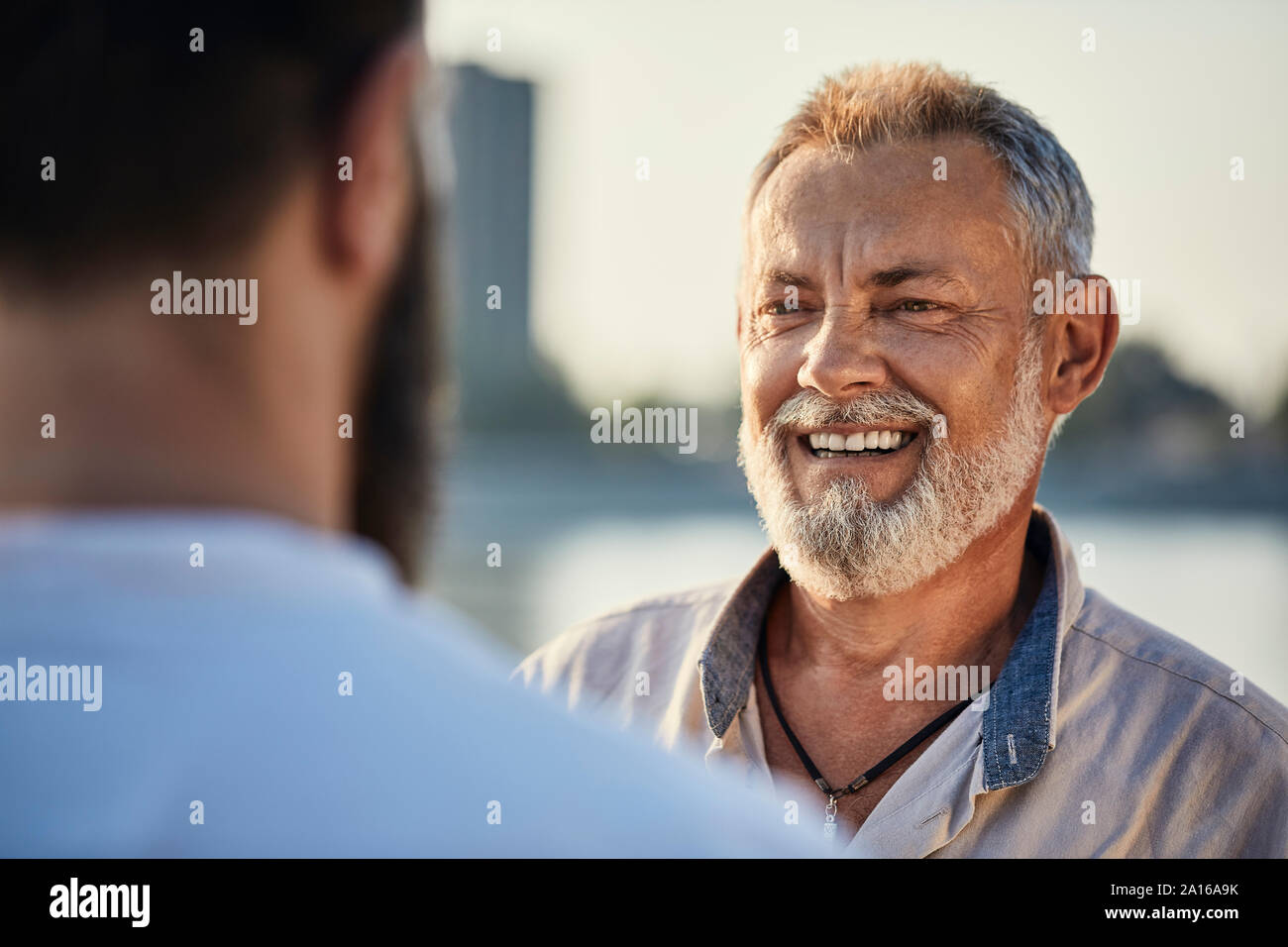 Gerne Vater im Gespräch mit erwachsenen Sohn im Freien Stockfoto