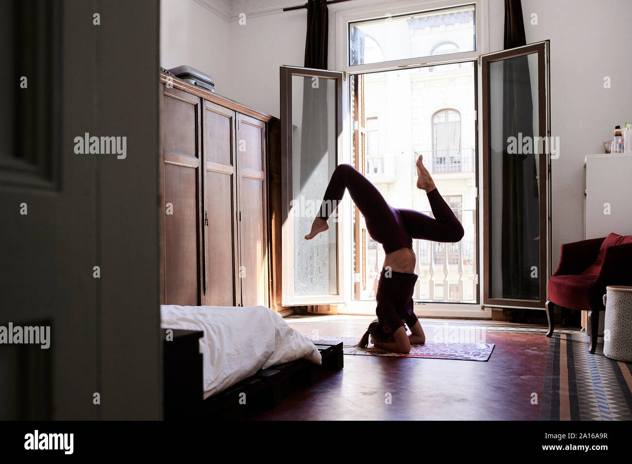 Junge brünette Frau Yoga in Studentenwohnheim Stockfoto
