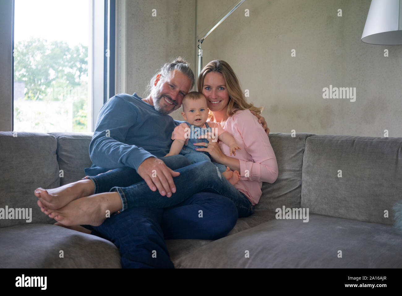 Portrait von Happy Family von drei Sitzen auf der Couch zu Hause Stockfoto