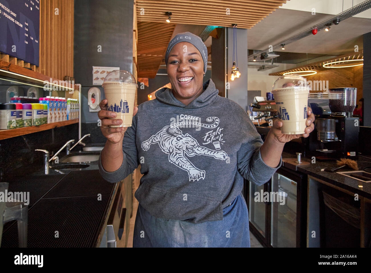 Glückliche junge Frau Milchshakes in einem Cafe Stockfoto