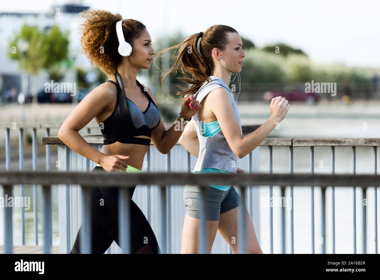 Zwei sportliche junge Frauen, die auf einer Brücke Stockfoto