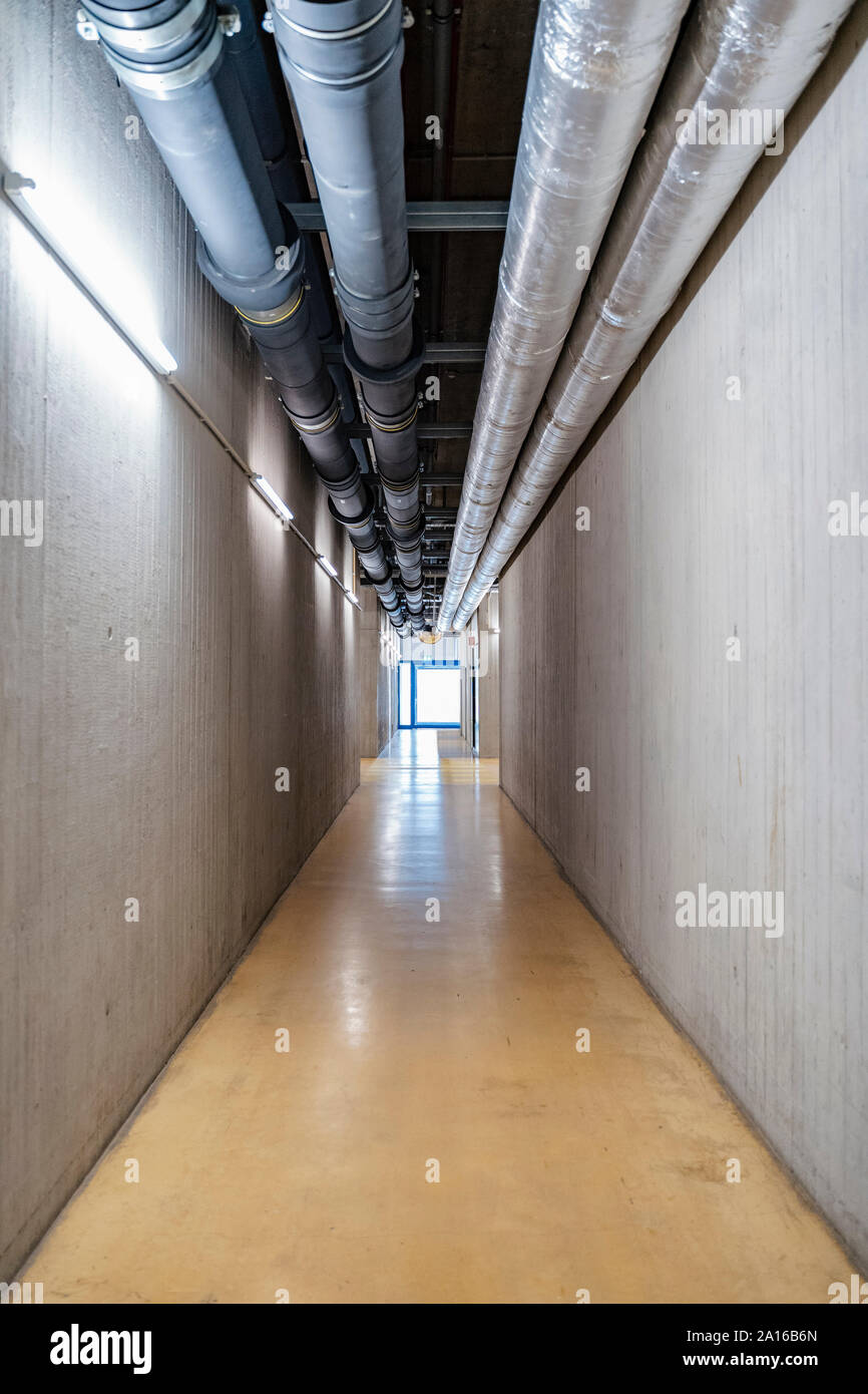 Rohre über leeren Korridor im Werk, Stuttgart, Deutschland Stockfoto