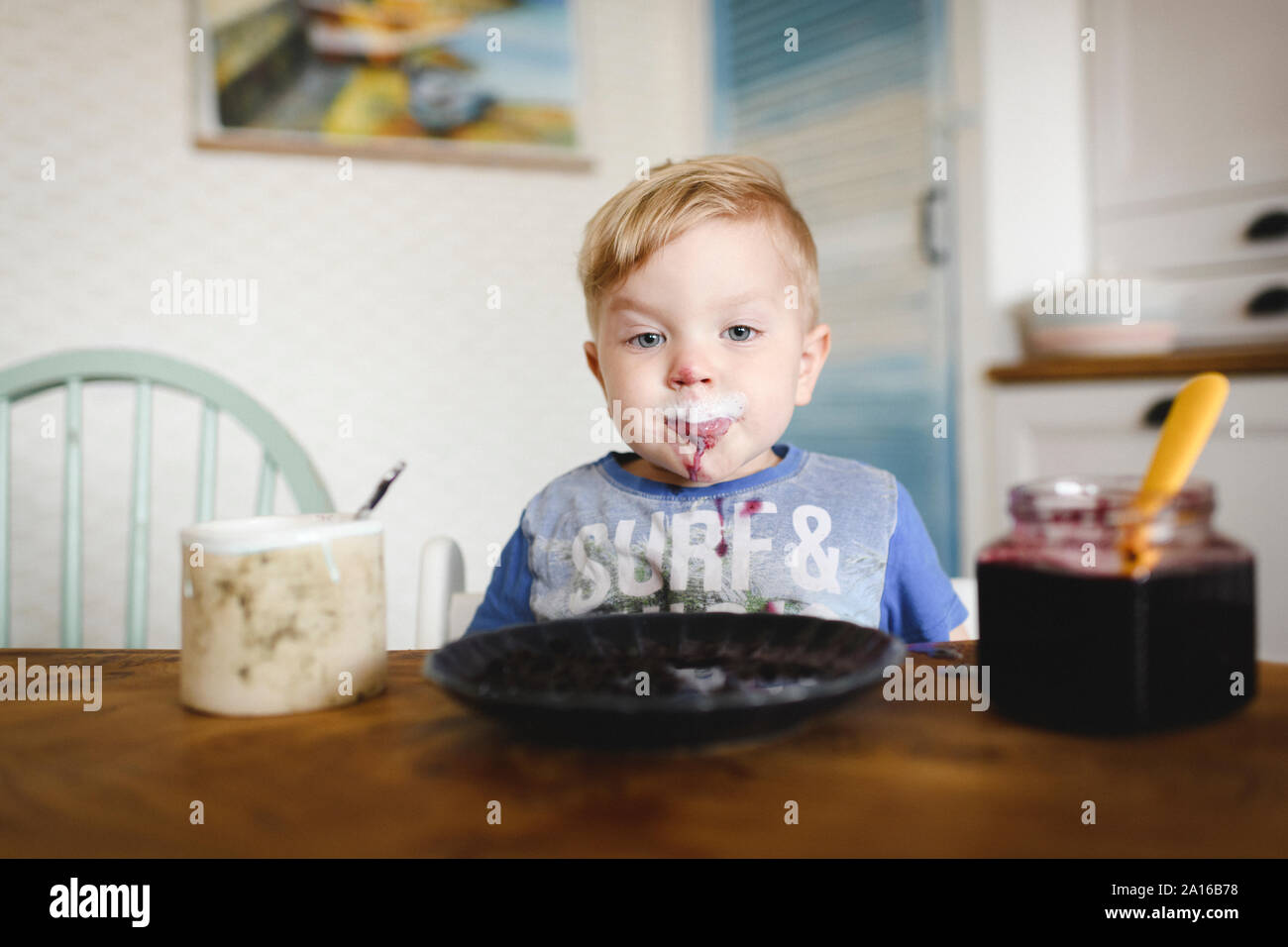 Portrait von niedlichen kleinen Jungen mit Blaubeer-marmelade in seinem Gesicht Stockfoto