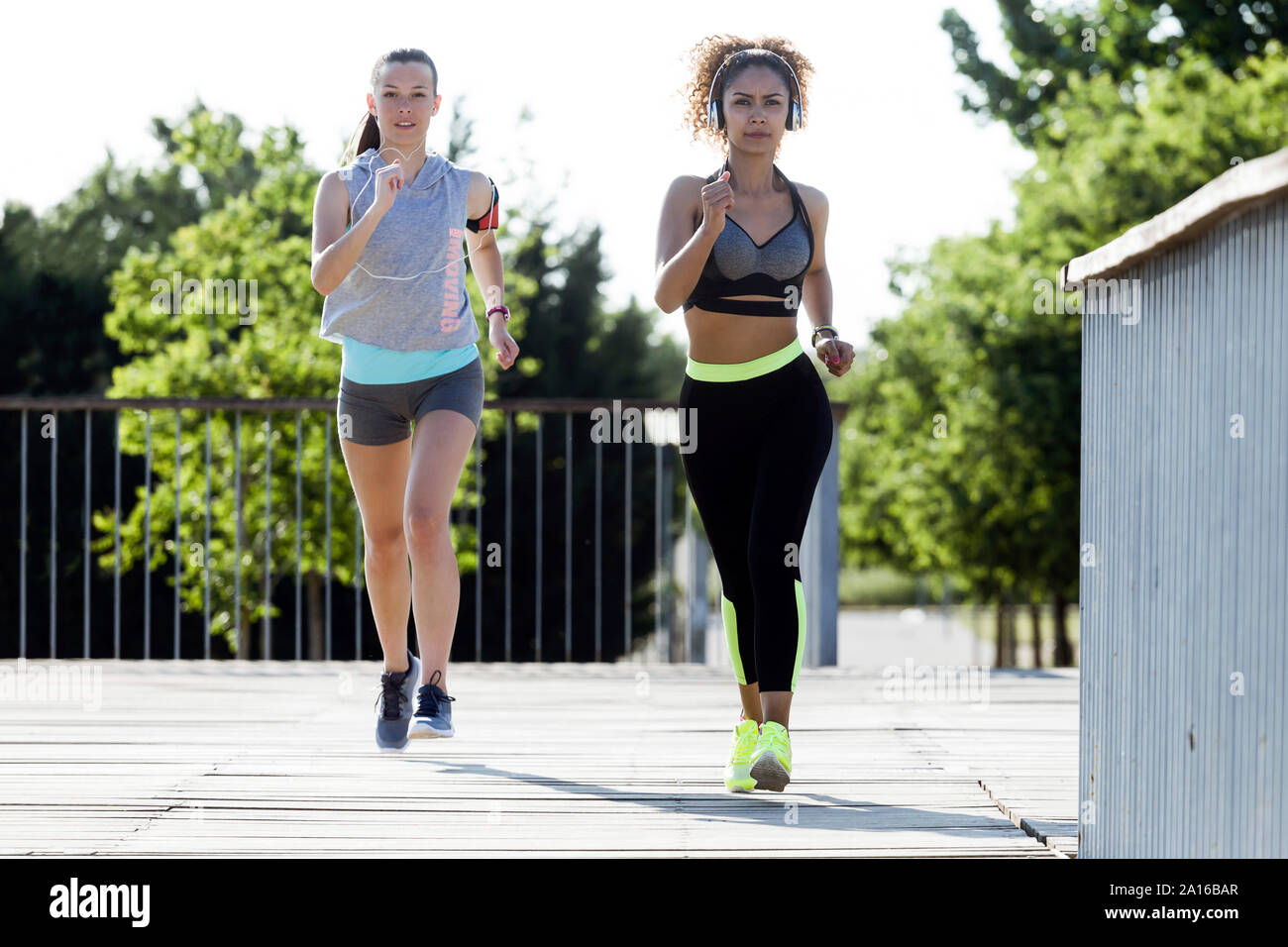 Zwei sportliche junge Frauen, die auf einer Brücke Stockfoto