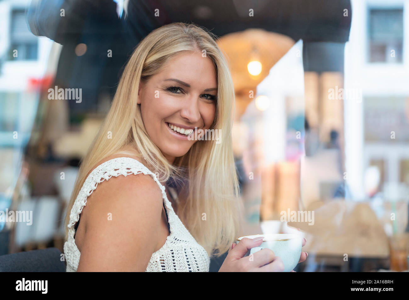 Portrait von lächelnden blonde Frau trinkt Kaffee in einem Cafe Stockfoto