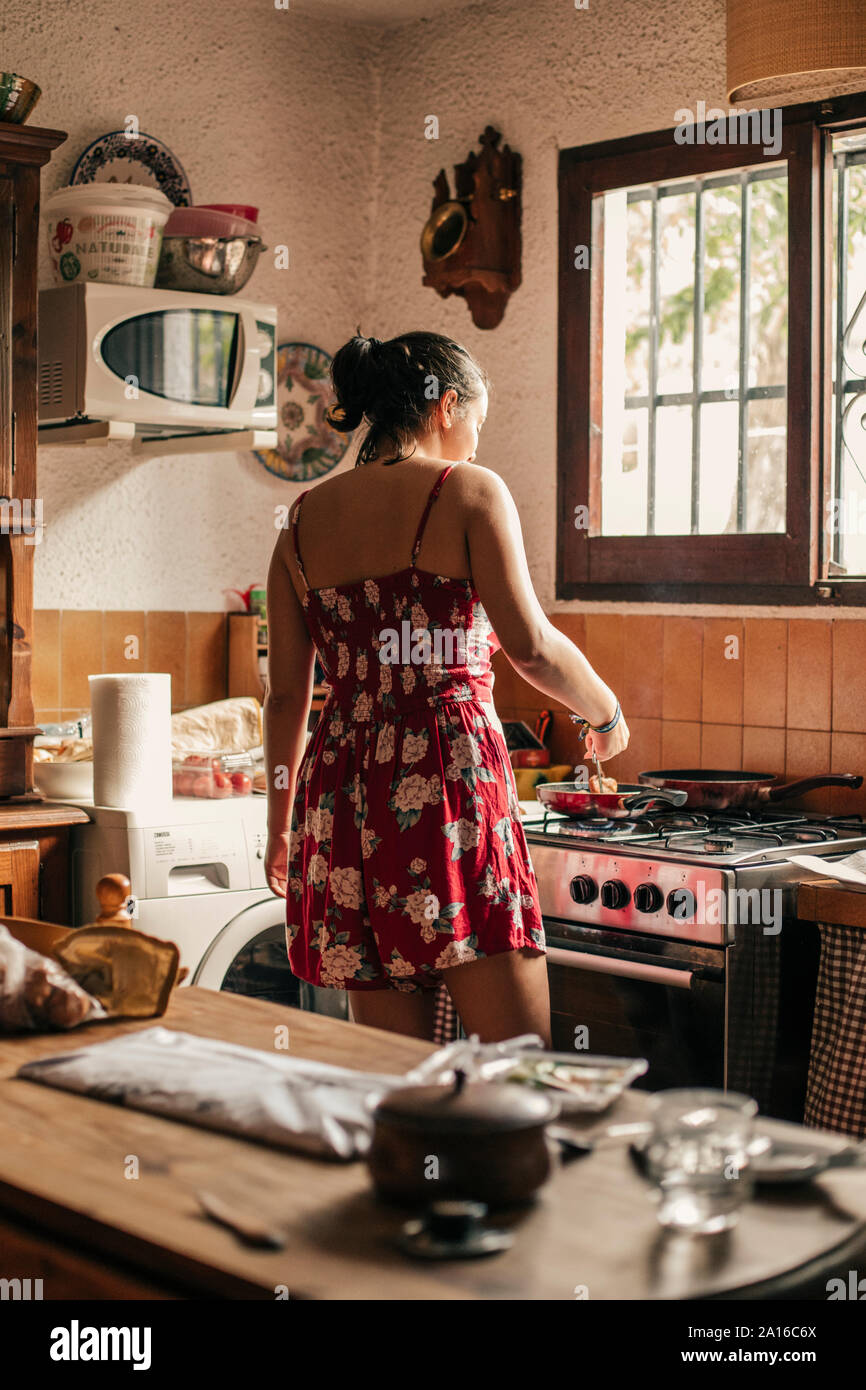Ansicht der Rückseite Frau Kochen in der Küche mit einer Pan Stockfoto