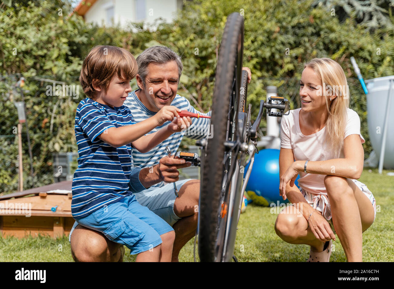 Familie Instandsetzung ein Fahrrad zusammen im Garten Stockfoto