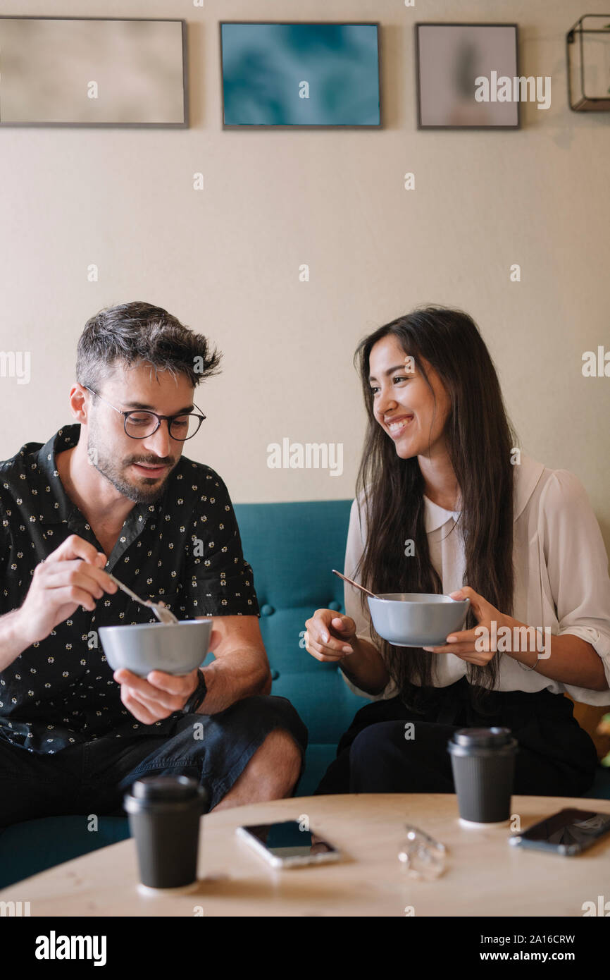 Junges Paar siiting auf einer Couch in einem Café frühstücken Stockfoto