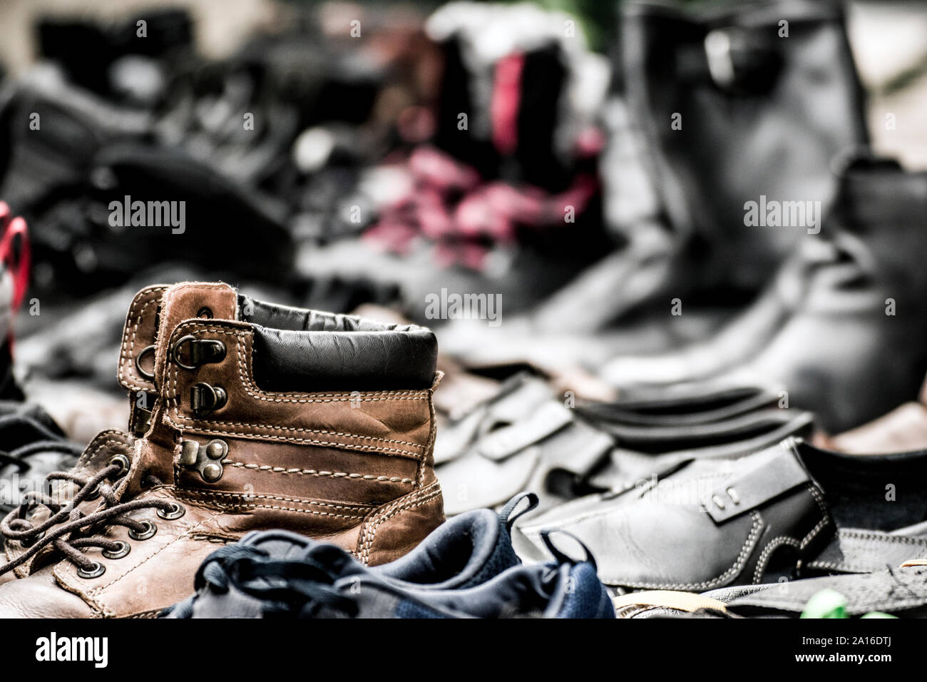 Paare von verschlissenen Schuhe mit ein paar klassischen alten Stiefel im Vordergrund; verschwommenen Hintergrund. Stockfoto