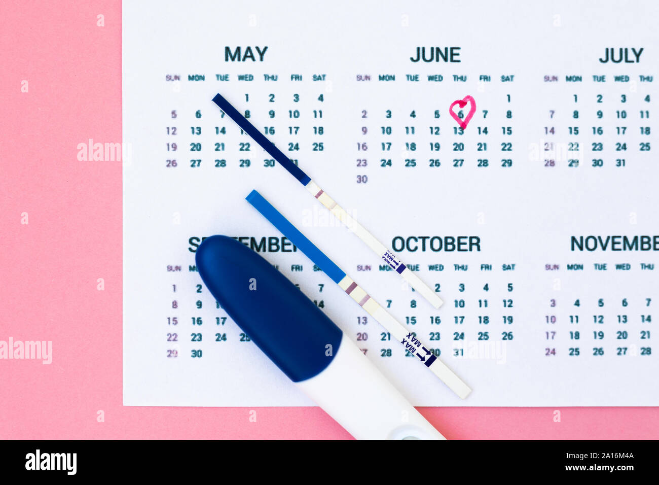 Eine Schwangerschaft planen. Positive Schwangerschaft Tests in der Nähe von  Kalender Seite auf rosa Hintergrund der Ansicht von oben kopieren Raum  Stockfotografie - Alamy