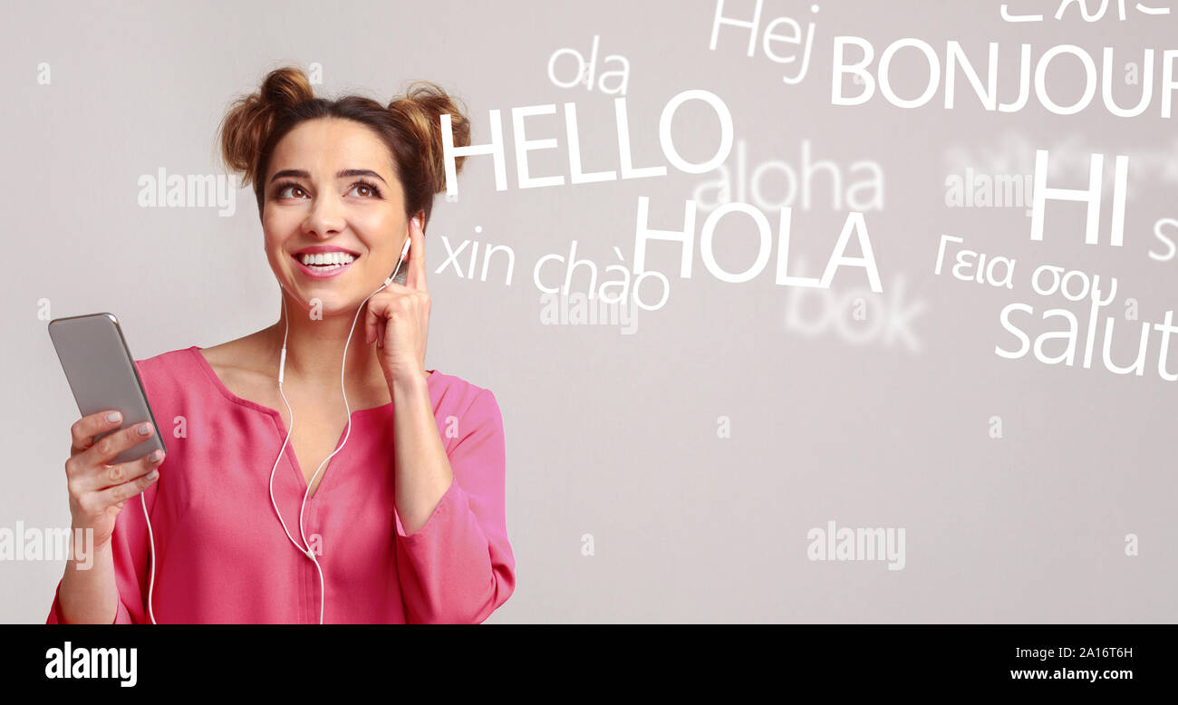 Frau mit Handy hören verschiedene Sprachen auf Grau Stockfoto