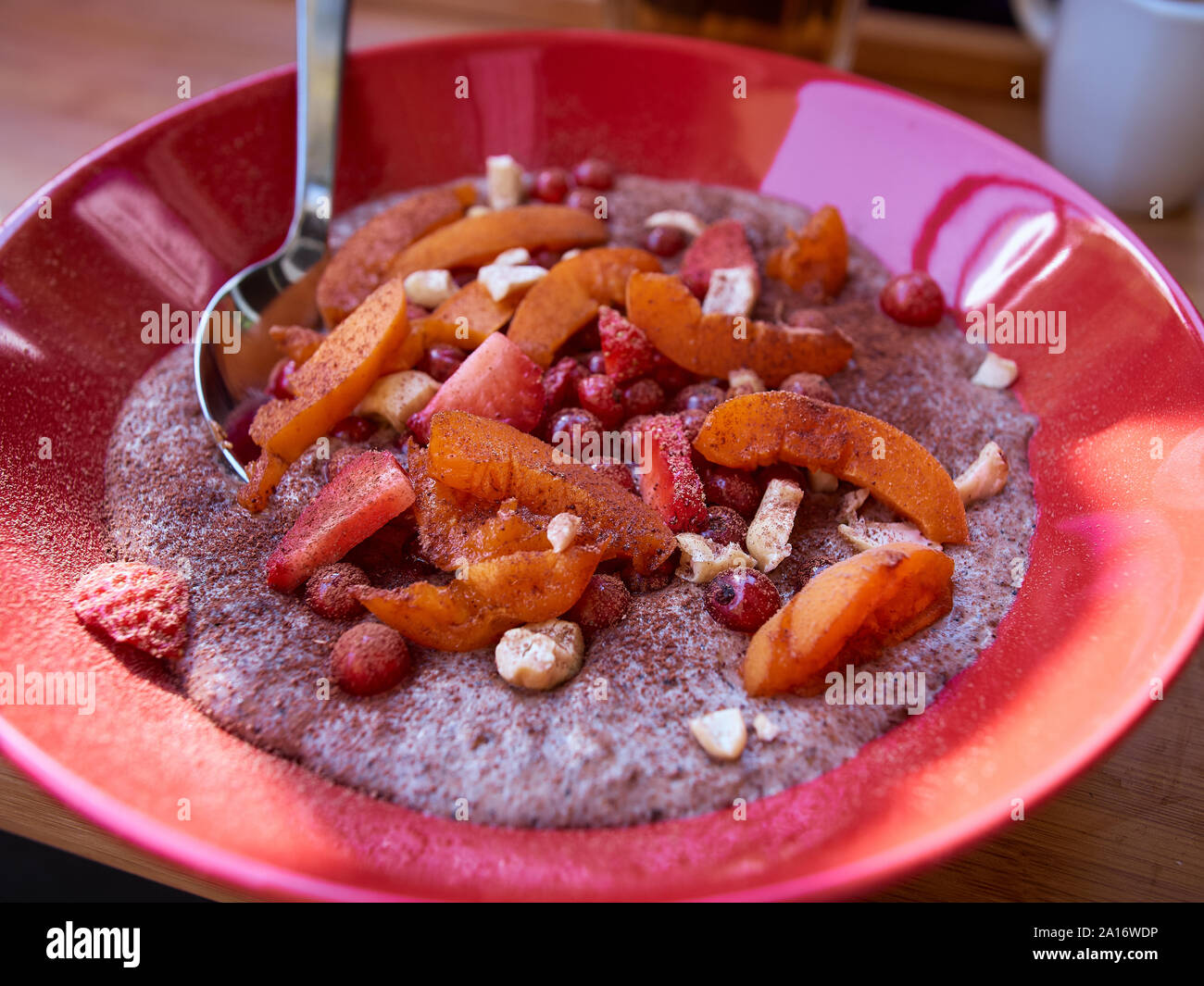 In der Nähe von zu Hause paleo Porridge aus Voll fett Kokosmilch und Samen mit organischen Früchten und Nüssen und ohne Zusatz von Zucker Stockfoto