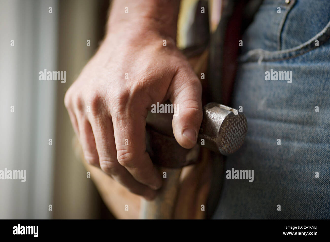 Die Hände eines männlichen Builder ruht auf einem Hammer. Stockfoto
