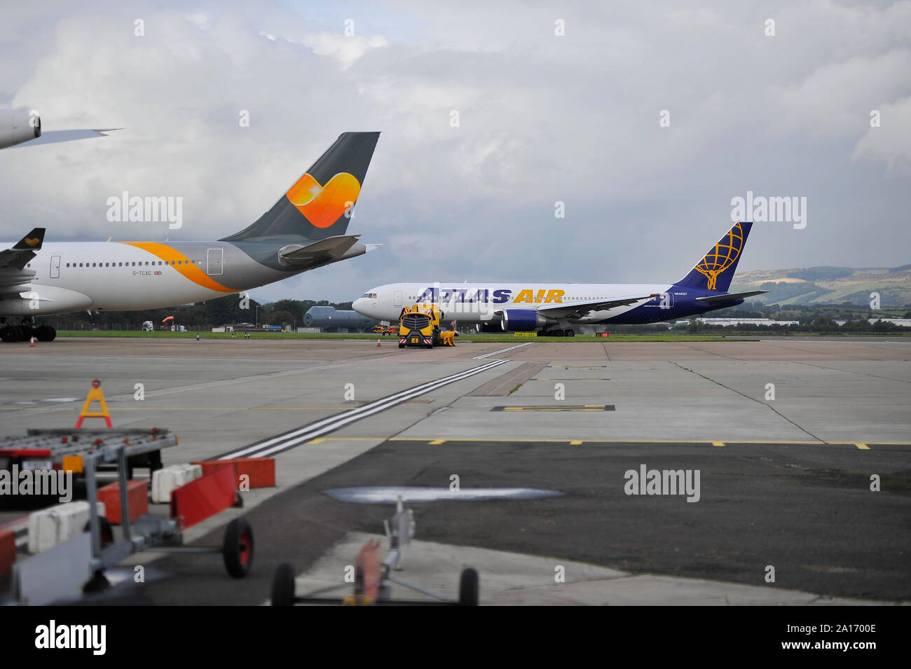 Glasgow, UK. 24. September 2019. Im Bild: Ein Airbus A 330200 Flugzeuge steht leer und gegründet auf der Rollbahn am Flughafen Glasgow. Glasgow Airport Authority haben 2 Hinweise zu den 2. Vorwärtsgang port side Beifahrertür Beratung, dass das Flugzeug aufgrund unbezahlter Landegebühren geerdet ist. Ein großer Schneepflug steht unter und hinter der Jet die Flugzeuge von der Rückseite aus seiner Position gedrückt zu verhindern. Die Atlas Air Boeing 767 im Hintergrund, die mehr Passagiere im Ausland zu sammeln. Colin Fisher/Alamy Leben Nachrichten Quelle: Colin Fisher/Alamy leben Nachrichten Stockfoto