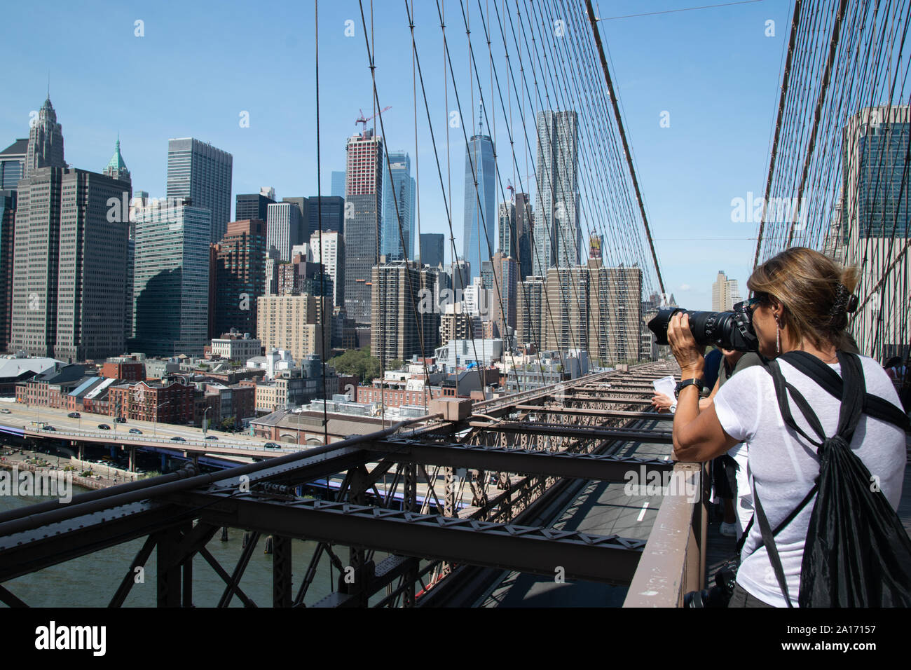 Frau Bilder aus Brooklyn Bridge vom Pier 17, dem South Street Seaport und die Skyline von Manhattan, New York City Stockfoto