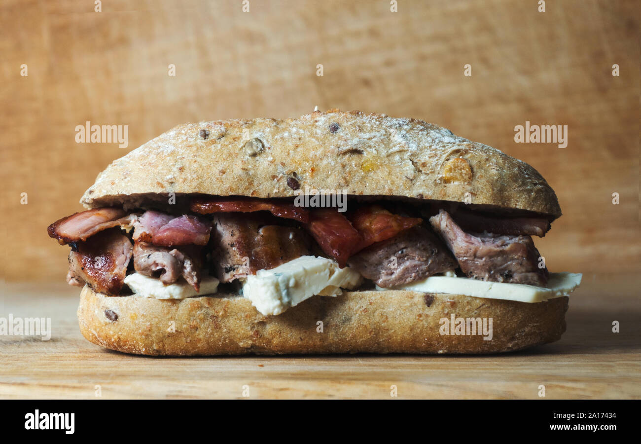 Schweinefilet Sandwich mit bluecheese und Speck auf den hölzernen Hintergrund Stockfoto