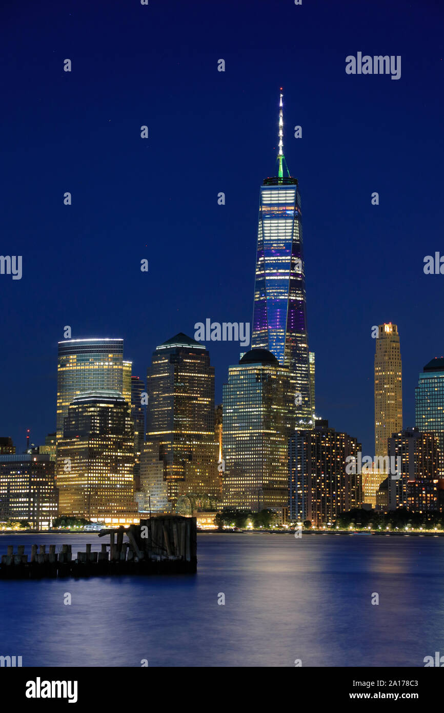 Nacht Blick auf das One World Trade Center und die Skyline von Lower Manhattan mit Hudson River im Vordergrund. New York City, USA. Stockfoto