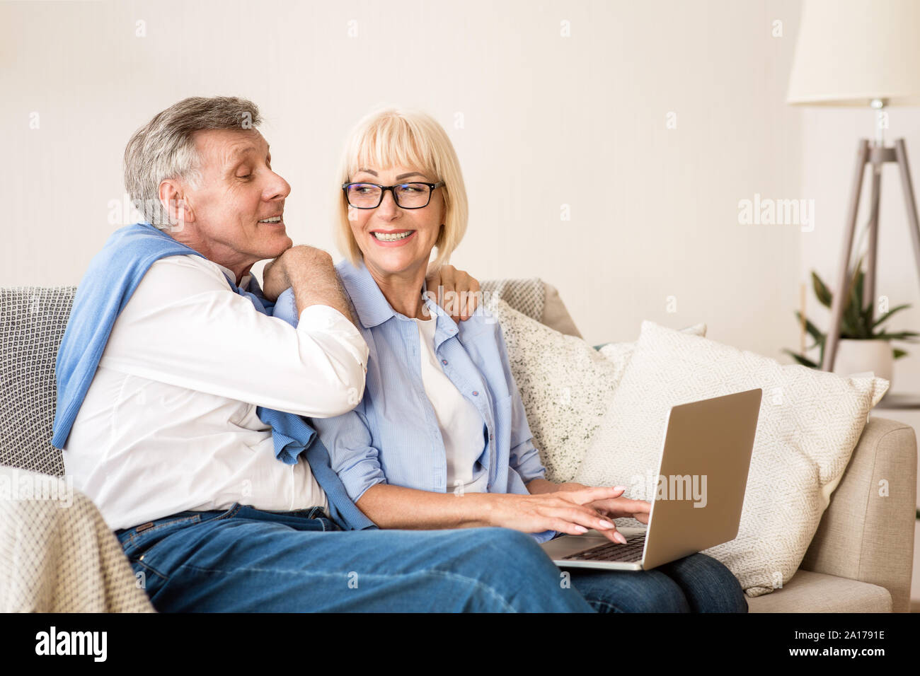 Gerne älteres Paar Surfen am Laptop zu Hause Stockfoto