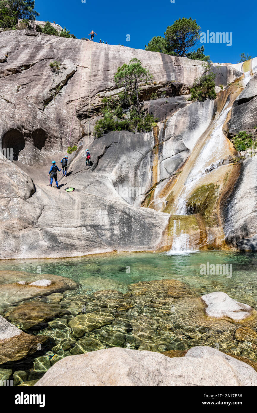 Menschen Canyoning in der berühmten Purcaraccia Canyon in Bavella im Sommer, ein Reiseziel für Canyoning, Besuch der natürlichen Pools. Korsika Stockfoto