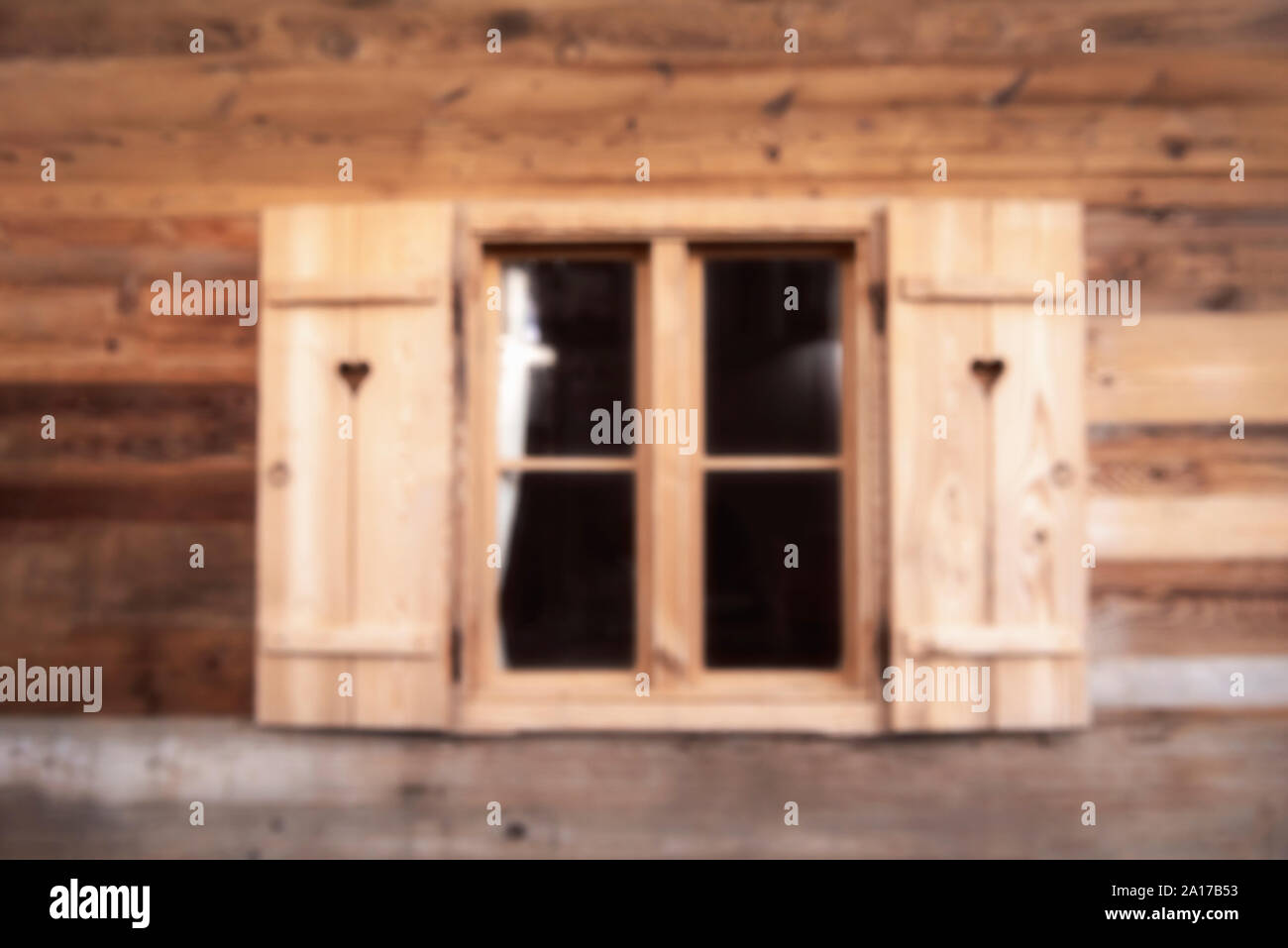 Malerische Holz Fenster mit Fensterläden aus Holz auf einem hölzernen Planken Wand. Süße Weihnachten Hausfassade blur Hintergrund. Defokussierten Bauholz cottage Fenster Stockfoto