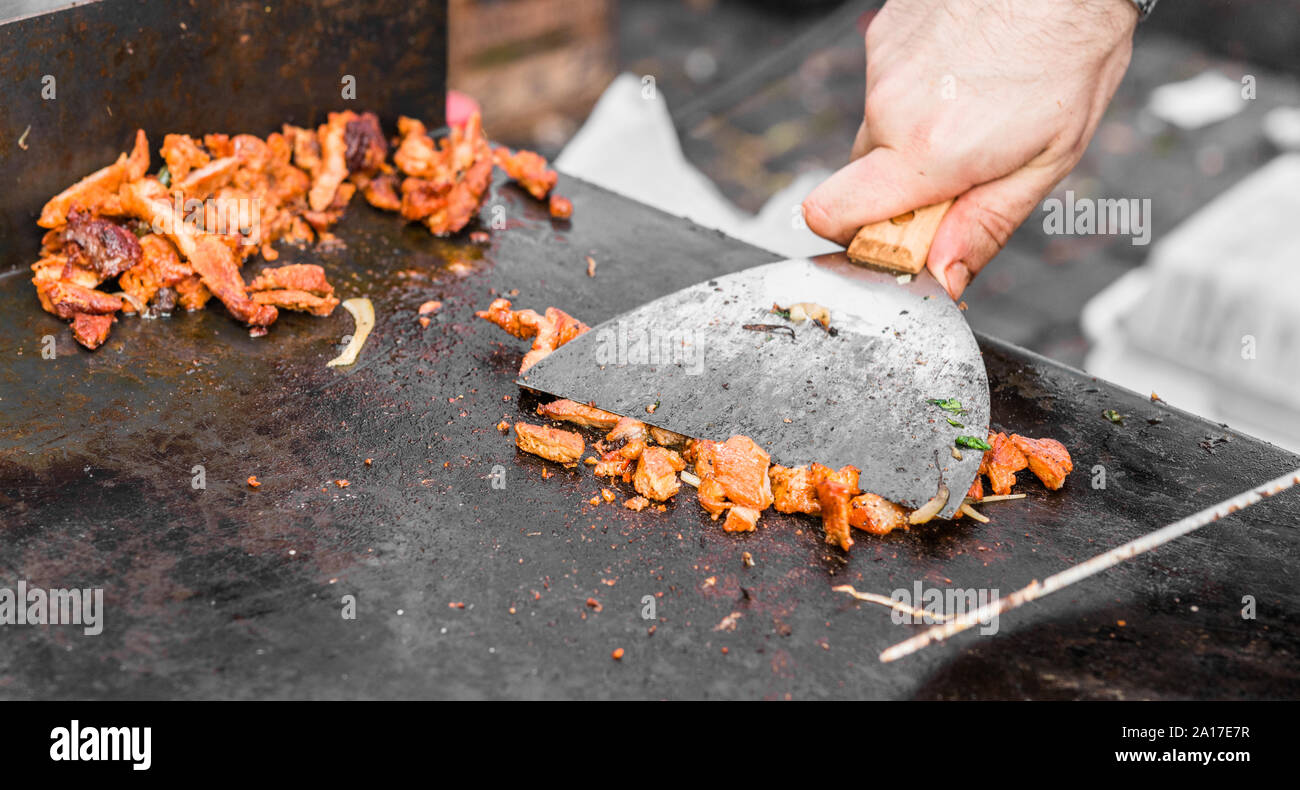 Koch Zubereitung Schweinefleisch für Tacos al Pastor zu einem Street Food Markt. Stockfoto