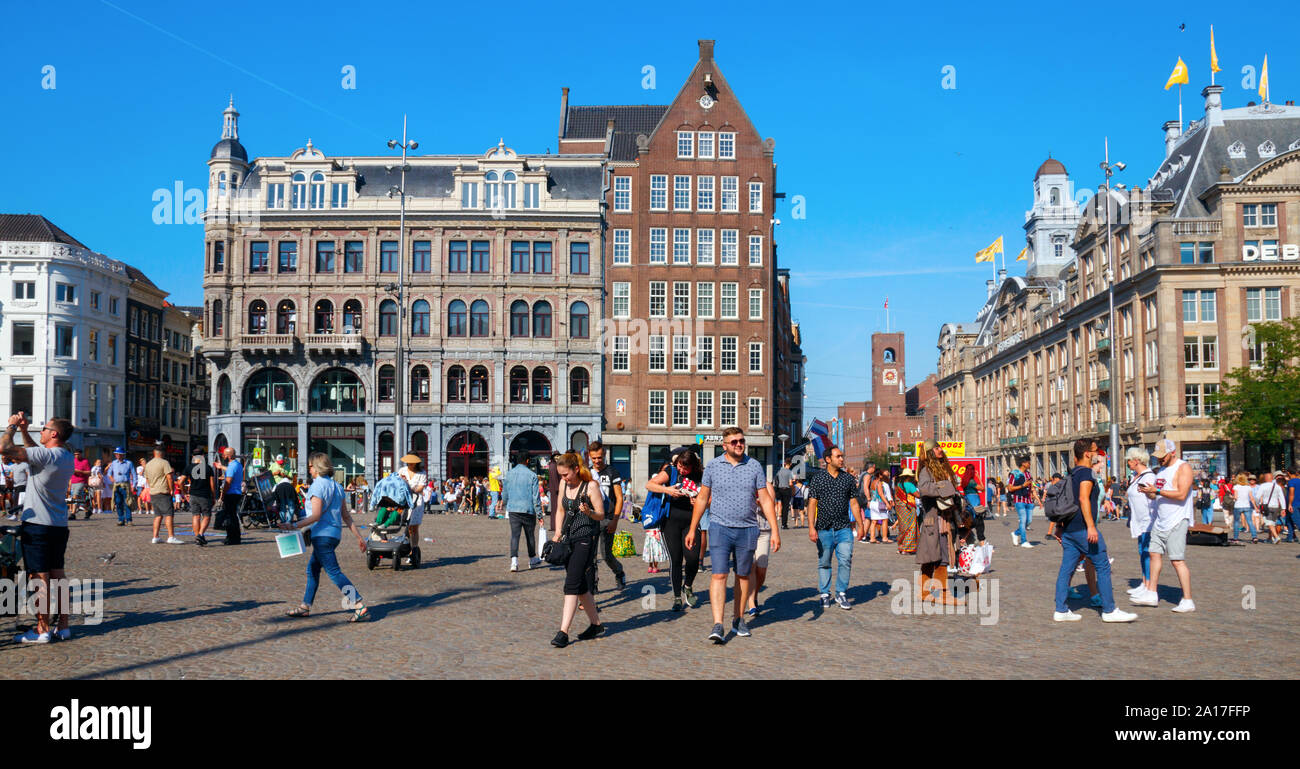 Der Dam Platz und der Damrak, überfüllt mit Touristen im Sommer in den Niederlanden. Dam Square ist eine wichtige touristische Attraktion von Amsterdam. Stockfoto
