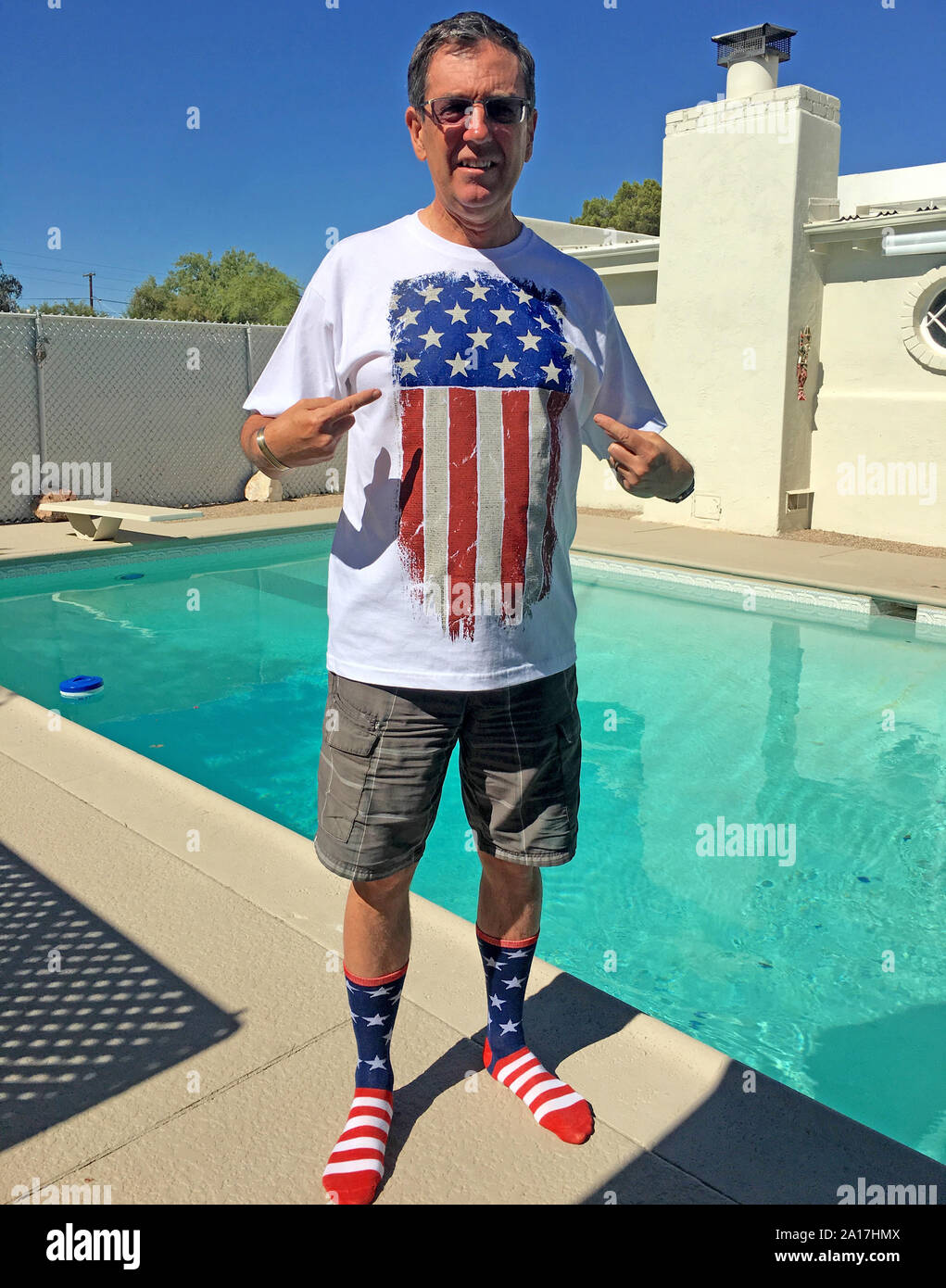 Patriotische männlichen Erwachsenen tragen eines Stars and Stripes t-shirt und Socken stehen ein Schwimmbad in Tucson AZ Stockfoto