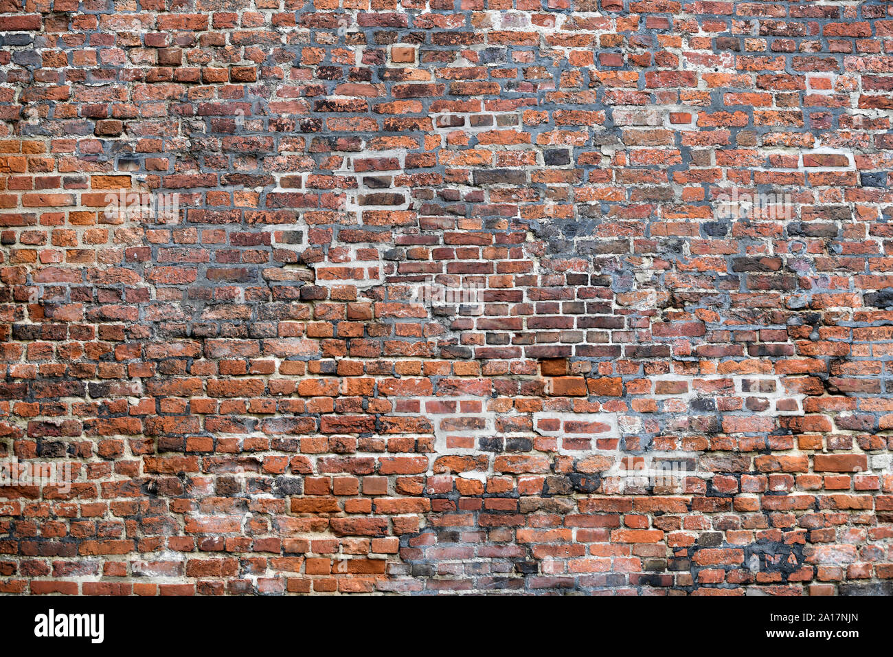 Old Red Brick Wall mit viel Struktur und Farbe. Stockfoto
