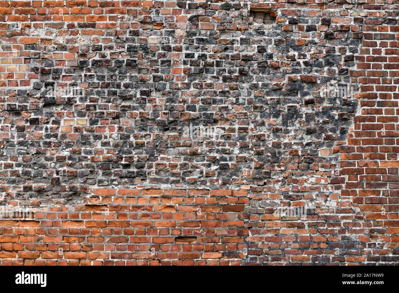 Old Red Brick Wall mit viel Struktur und Farbe. Stockfoto