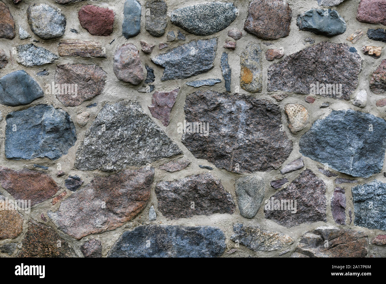 Alte Steinmauer mit viel Struktur und Farbe. Stockfoto