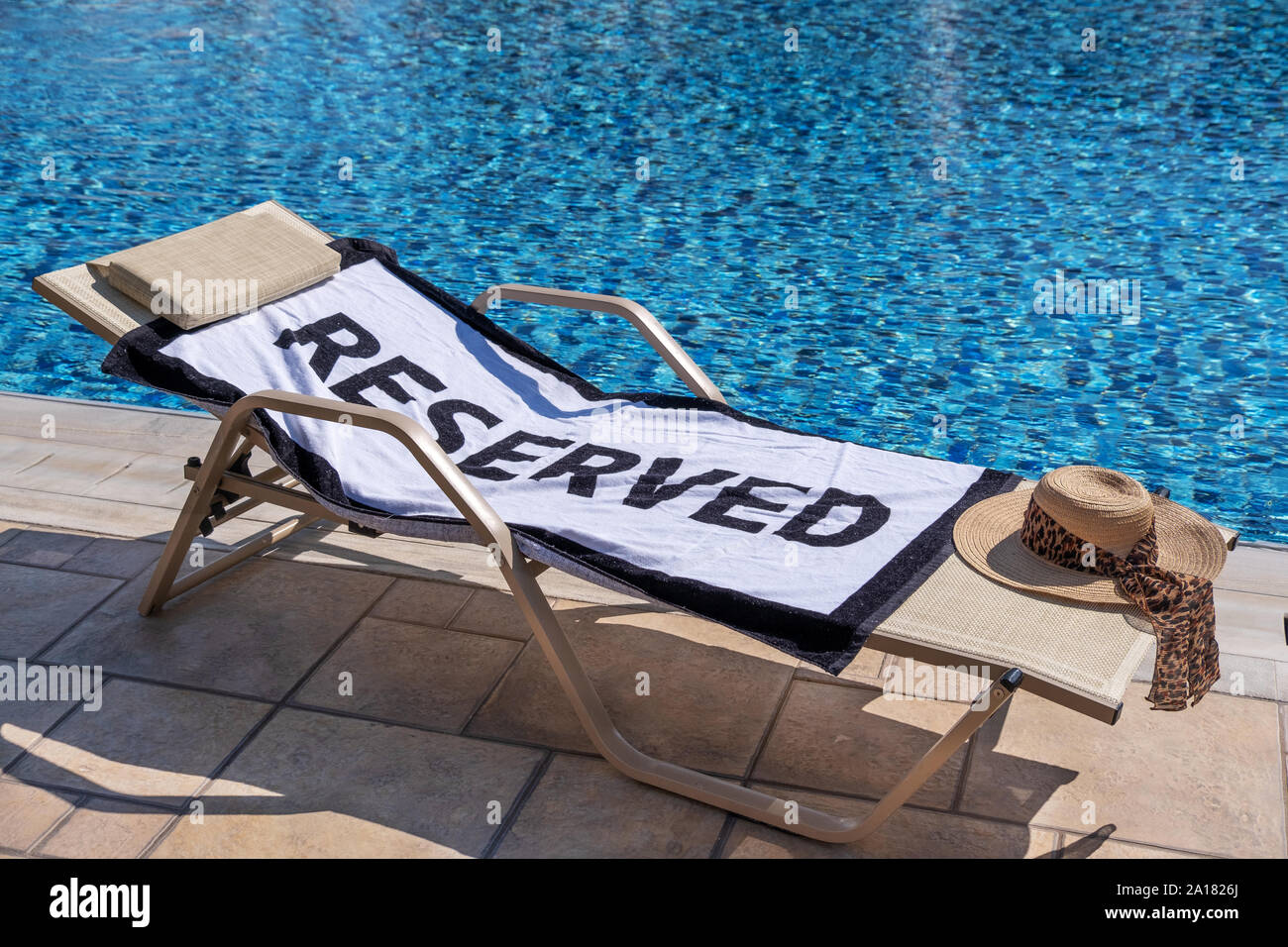 Ein reservierter Liegestuhl am Pool Stockfoto