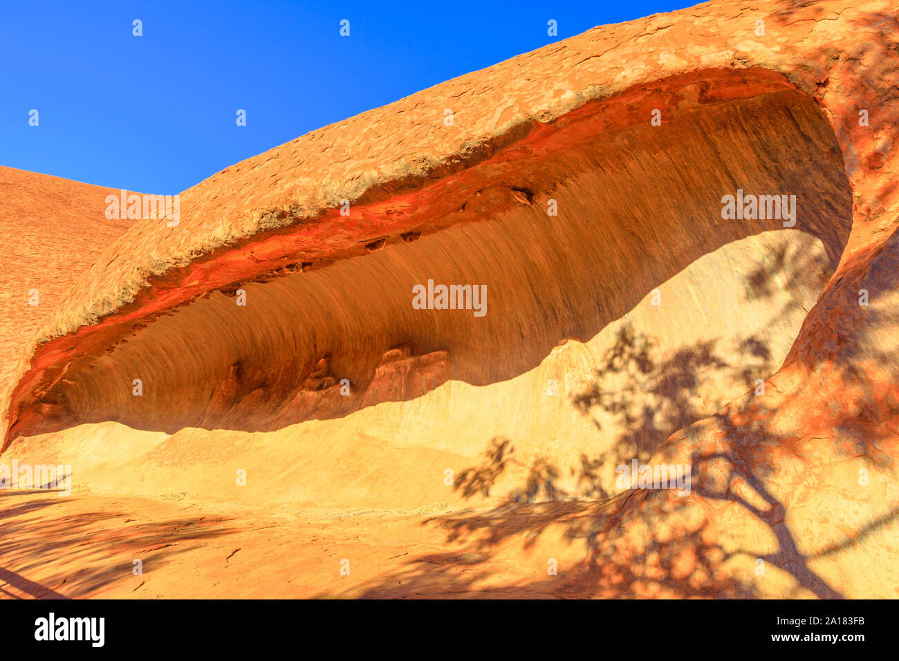 Kulpi watiku bei Sonnenuntergang, Senior Höhle von Männer entlang Mala Spaziergang an der Basis des Ayers Rock in den Uluru-Kata Tjuta National Park, wenn Mala, Anangu s Stockfoto
