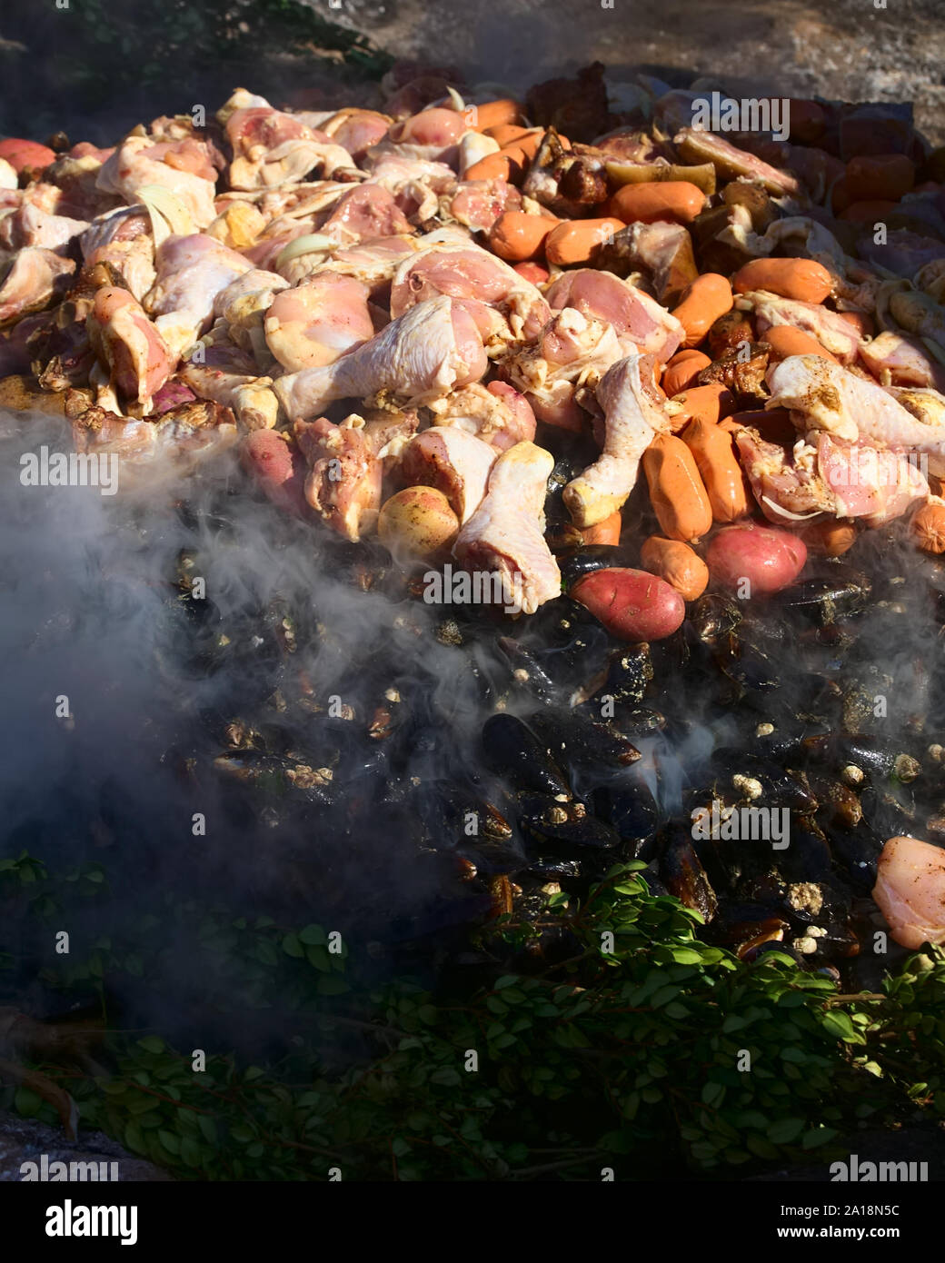 ACHAO, CHILE - Februar 6, 2016: Das traditionelle Gericht Chilotan Curanto al Hoyo in einem Loch im Boden vorbereitet wird. Stockfoto