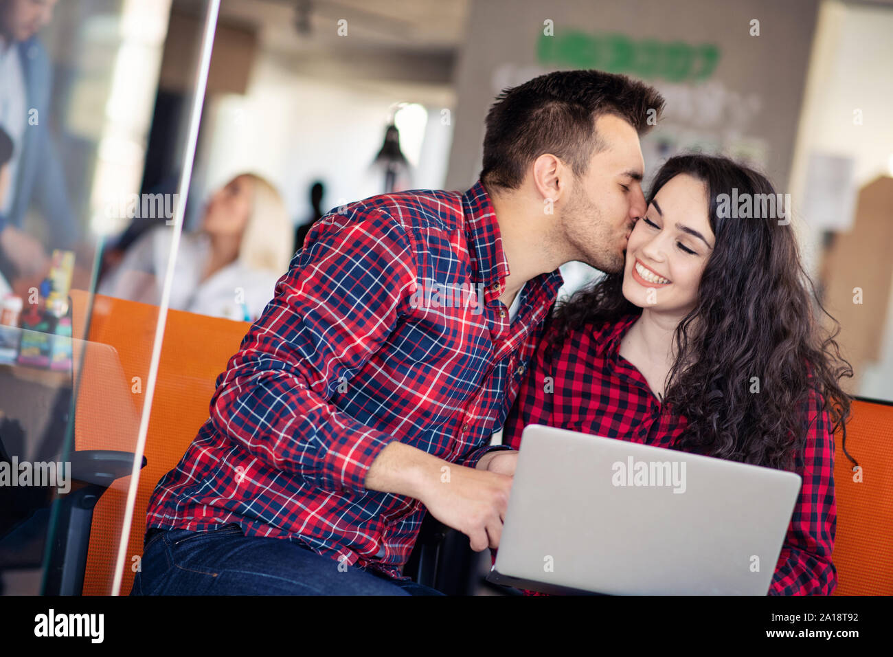 Glückliches junges paar Küssen im Büro Stockfoto