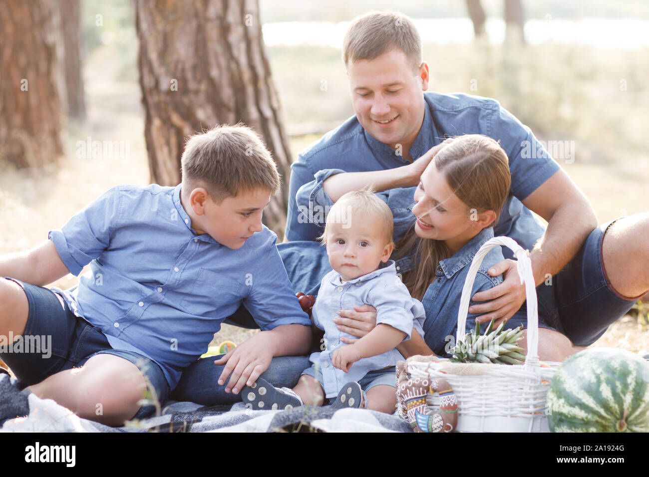 Schöne glückliche Familie - Eltern und zwei Söhne, verbringen viel Zeit in der Natur, Lachen, Essen frische Früchte Stockfoto