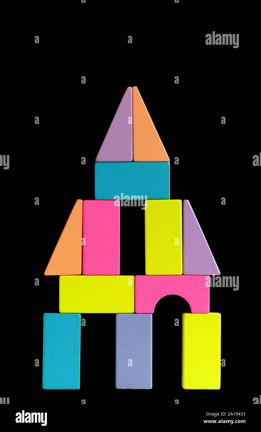 Imaginäre Konstruktion von bunten Holzklötzen über dunklen Hintergrund Stockfoto