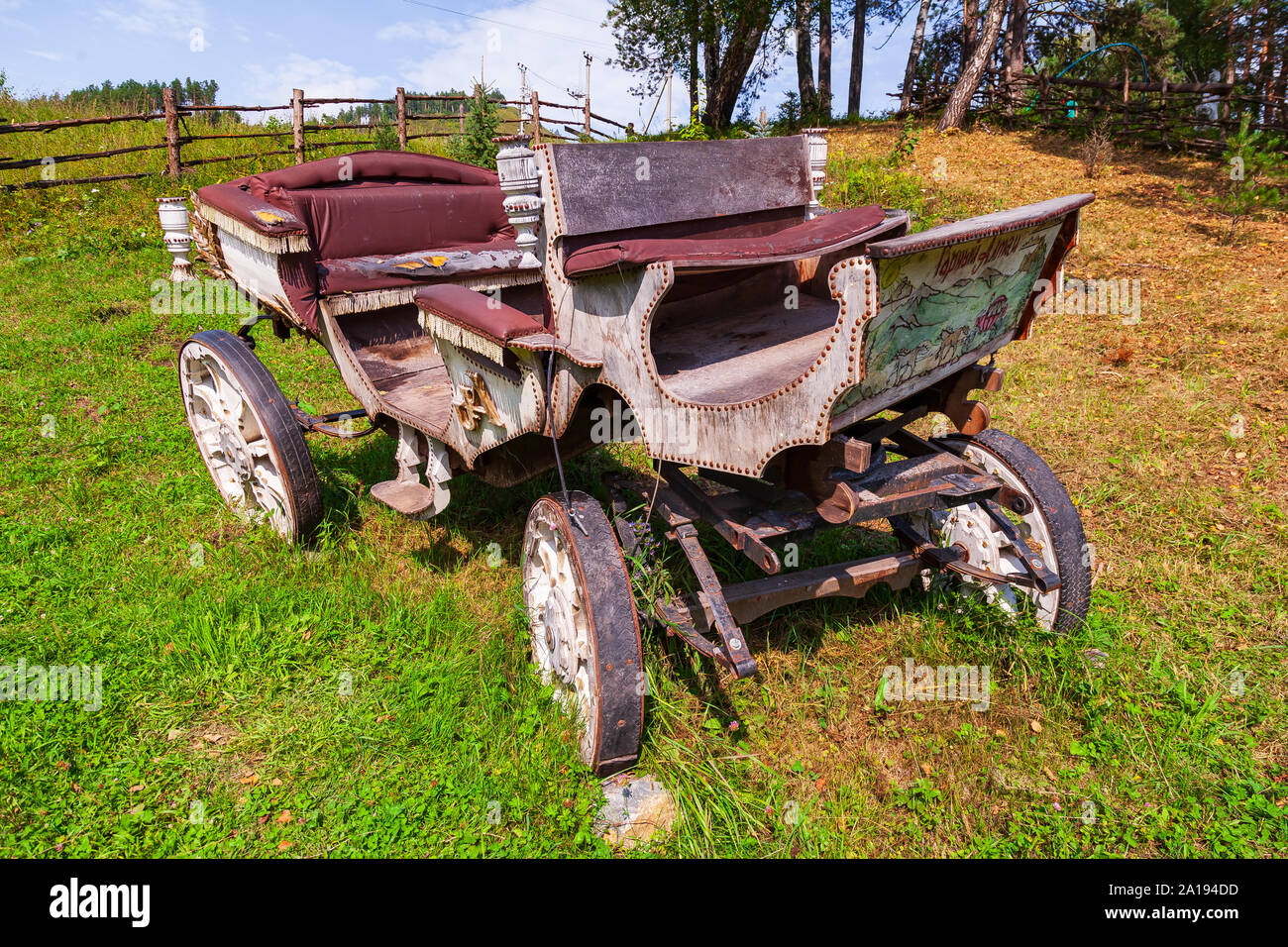 Altai, Russland - 09.25.2019: Einem alten Schlitten aus Holz mit großen Rädern ohne Pferd an einem Berghang auf grünem Gras. Retro und Vintage aus. Stockfoto