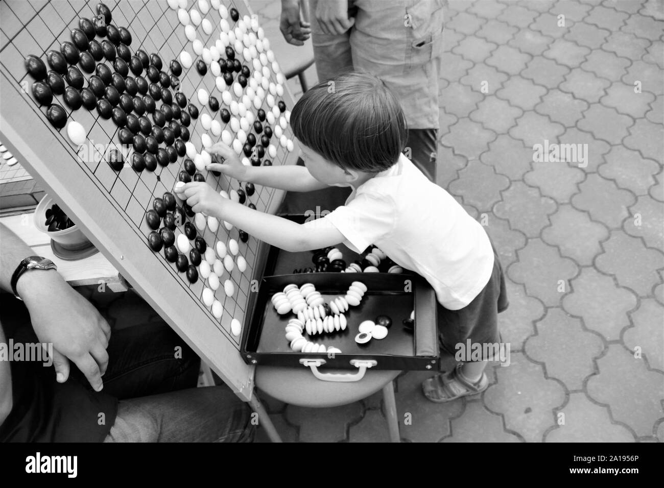 Junge spielt chinesischen Spiel gehen, Nahaufnahme, Schwarz und Weiß Stockfoto