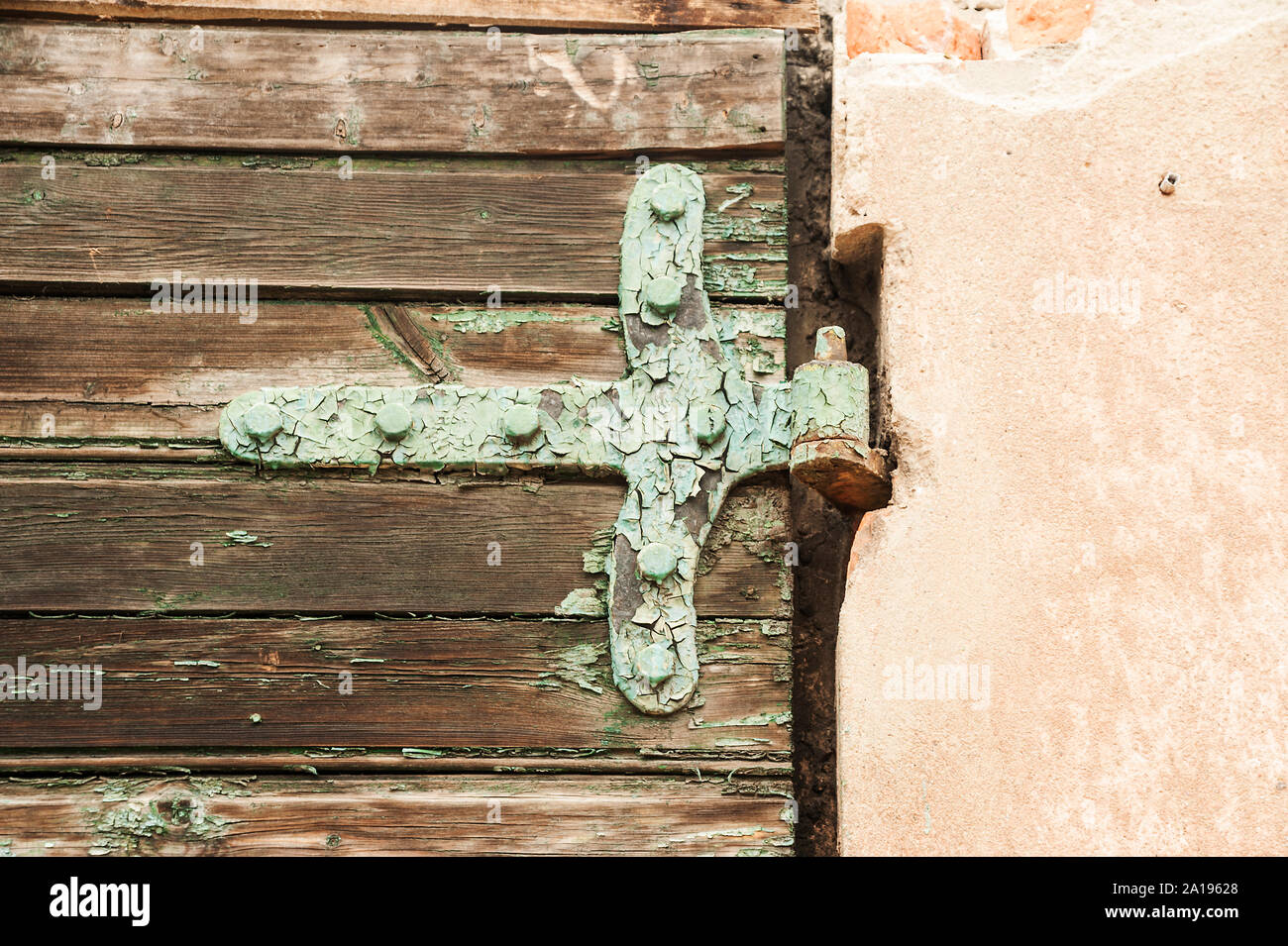 Alte Holztür mit einem dekorativen Scharnier Stockfoto