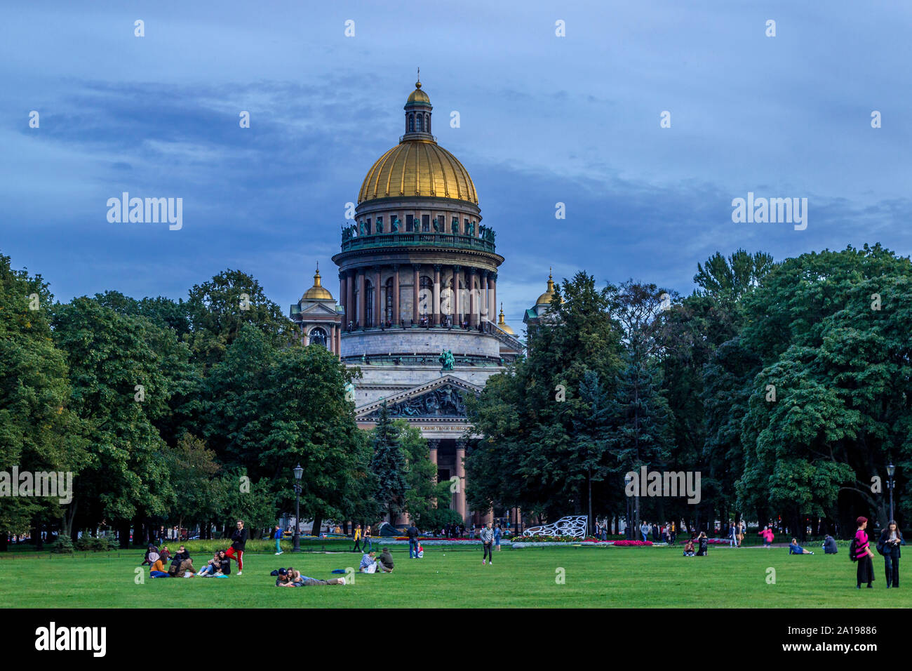 Isaak-kathedrale fotografierte während des Abends mit Menschen saßen auf dem Gras, in St. Petersburg, Russland. Stockfoto