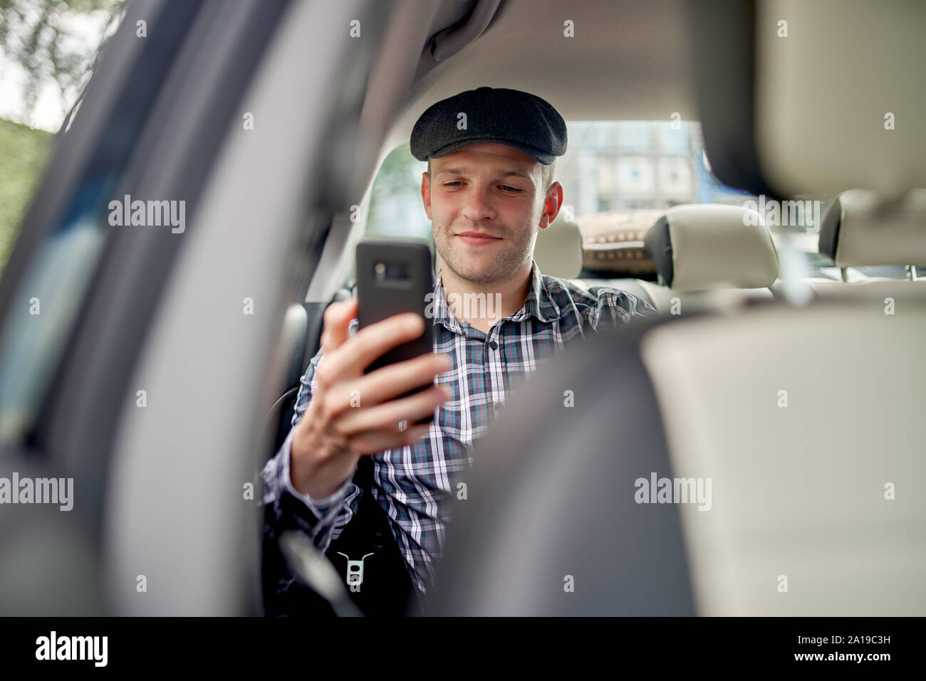Foto von Mann mit Handy in der Hand Autofahren bei Tag Stockfoto