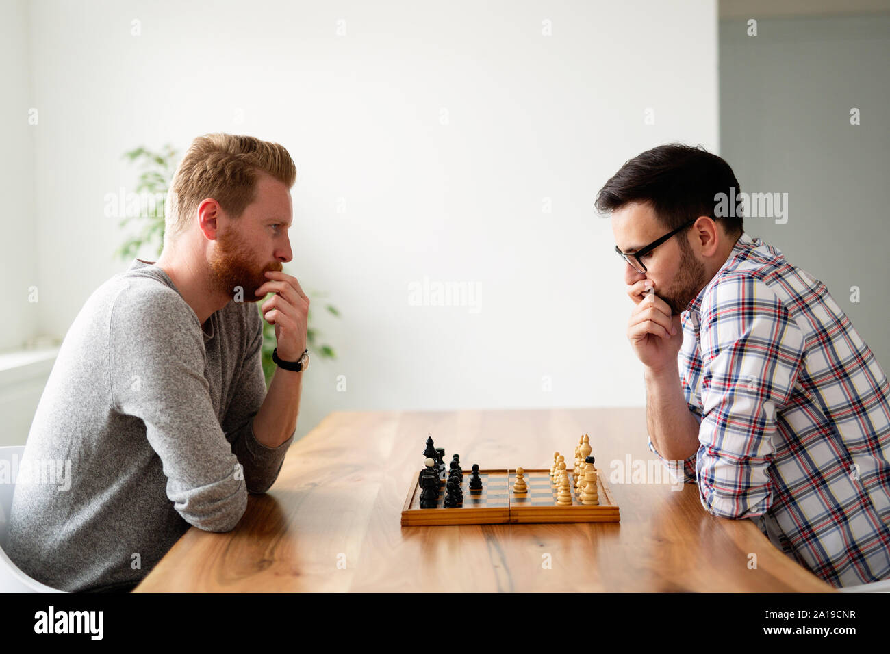 Porträt von zwei jungen Mann spielen Schach Stockfoto