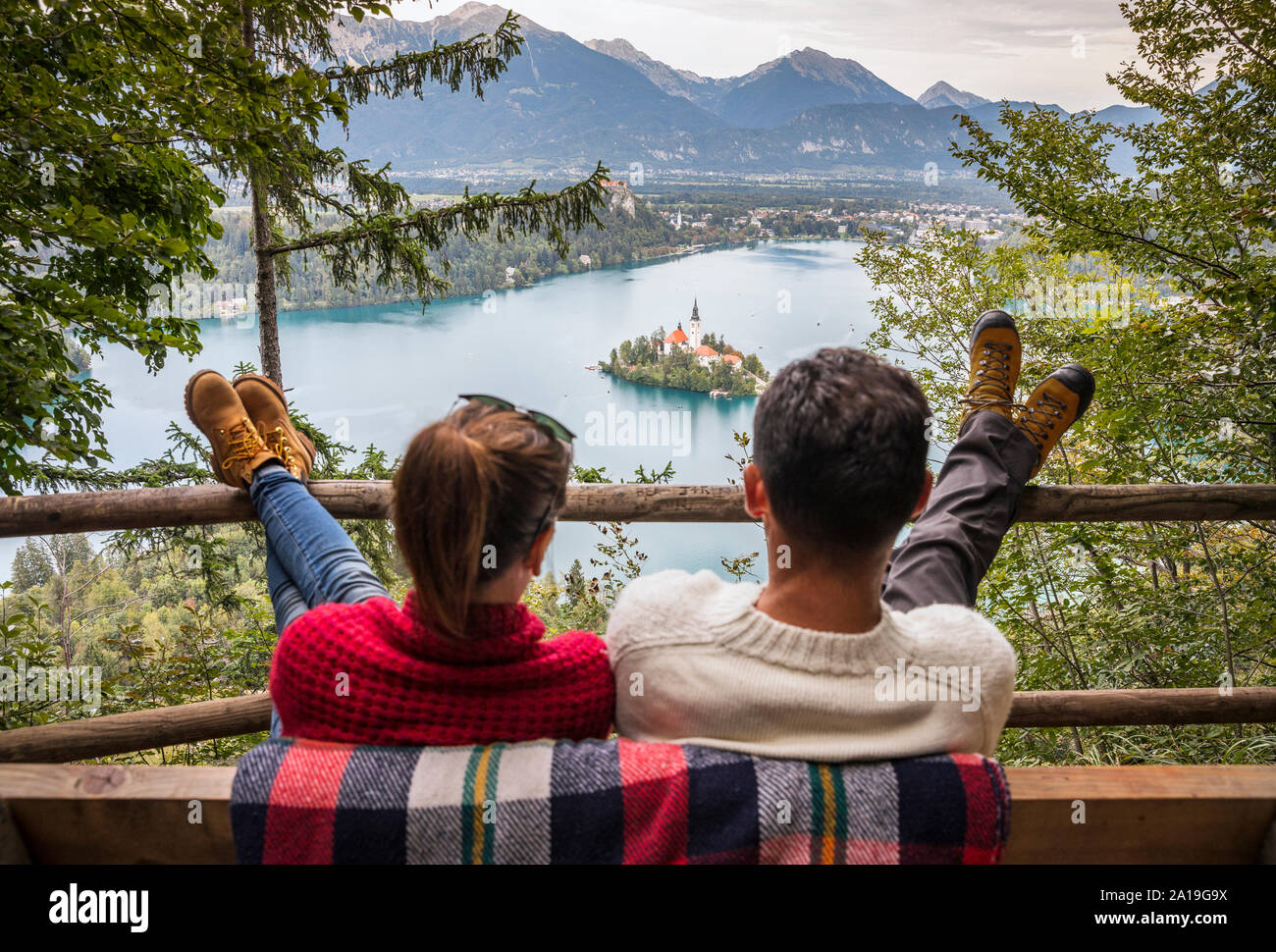 Junge Paar genießt die Aussicht auf den Bleder See aus dem Hügel Stockfoto