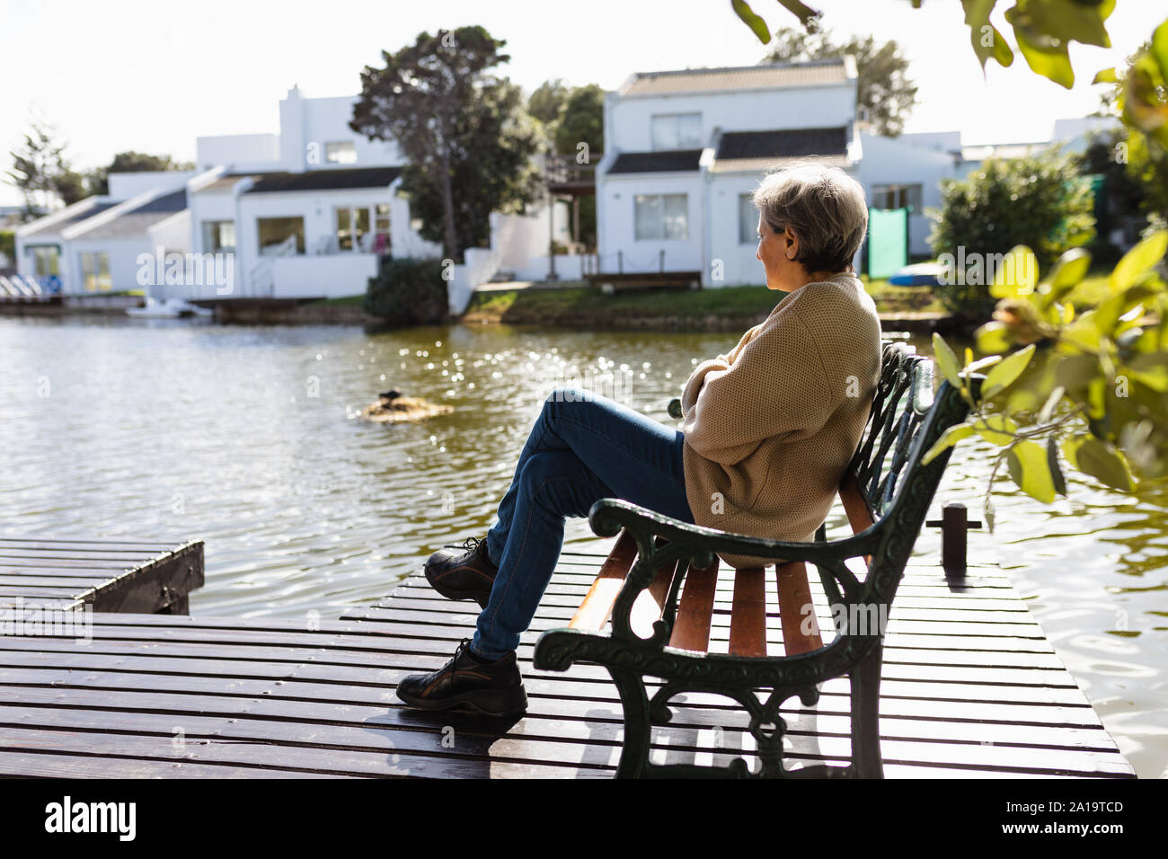 Ältere Frau, die ihre freie Zeit genießen, an einem See Stockfoto