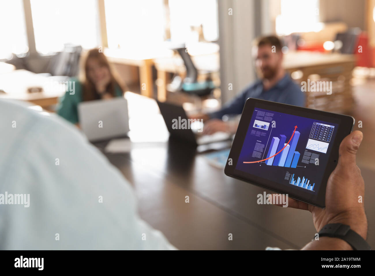 Junge kreative Professionelle man mit Tablet-PC in einem sonnendurchfluteten Büro Stockfoto