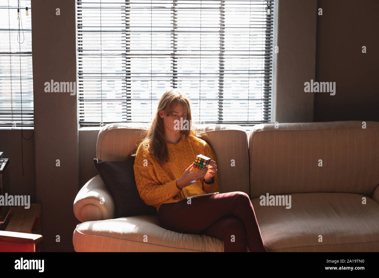 Young Creative Professional Frau mit Smartphones in der sonnendurchfluteten Büro Stockfoto