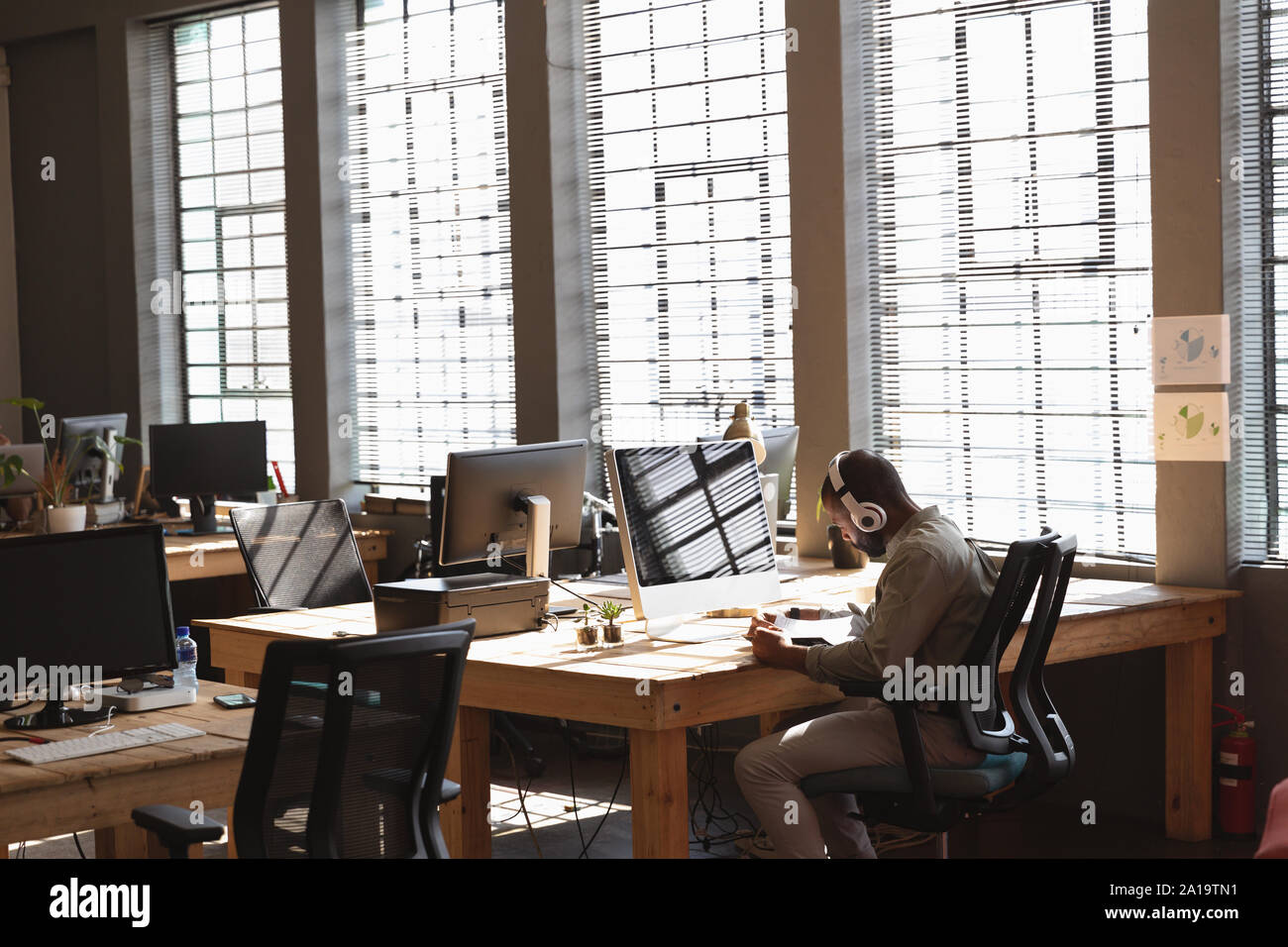Young Creative Professional Mann bei der Arbeit in einem sonnendurchfluteten Büro Stockfoto