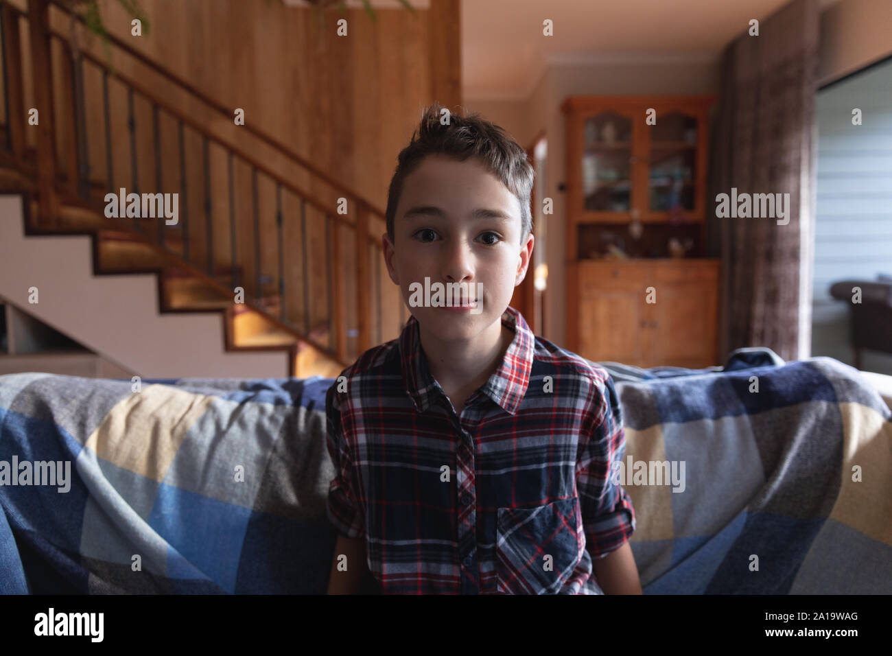 Junge sitzt auf einer Couch zu Hause Stockfoto