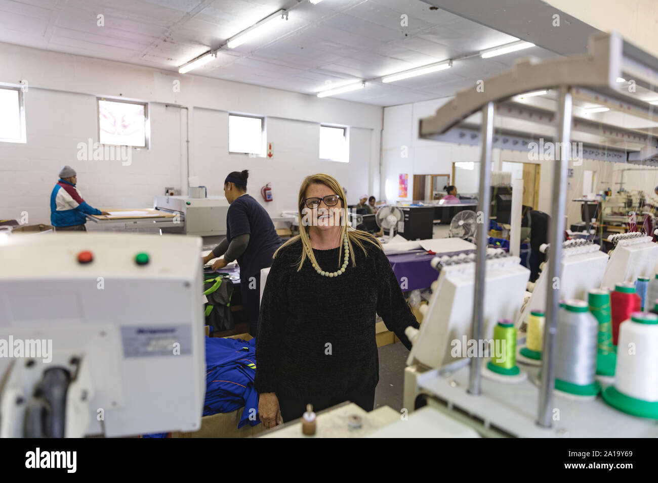 Porträt einer Frau mittleren Alters in einer Kleiderfabrik Stockfoto